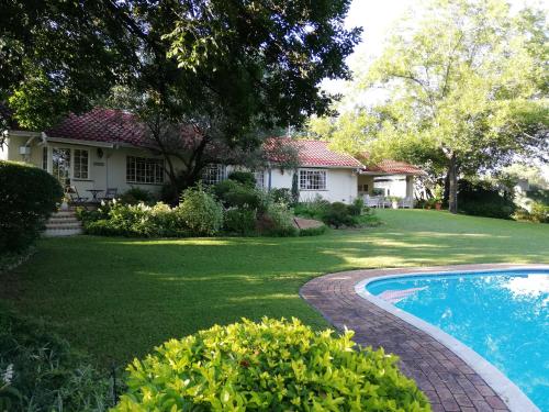 约翰内斯堡Tiree B&B的一个带房子和游泳池的庭院