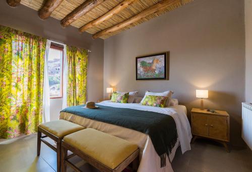 蒂尔卡拉德尔切洛别墅酒店的一间卧室设有一张大床和一个窗户。