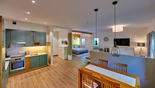 基姆高地区阿绍Ferienwohnung Sicado Loft的厨房和带绿色橱柜的客厅
