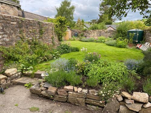 蒂弗顿Six on Castle的一座带石墙和鲜花的花园