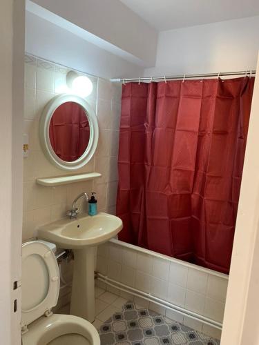 拉纳卡Green Nondas Hill的浴室设有卫生间、水槽和红色的淋浴帘