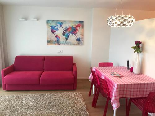菲耶Casa Sciliar centro paese PINK的客厅配有红色的沙发和桌子