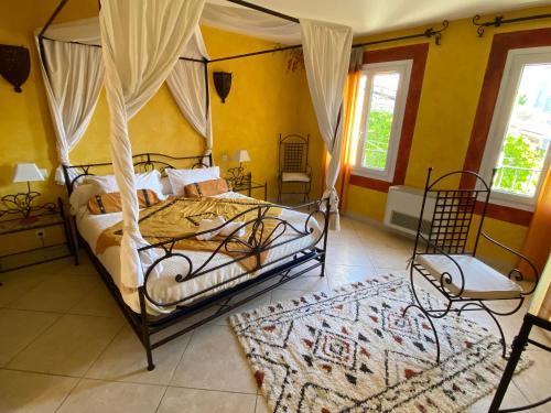 普伊若Le Rif的一间卧室配有一张天蓬床和地毯。