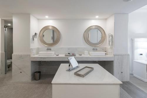 亚松森米西翁精品酒店的白色的浴室设有2个水槽和2面镜子