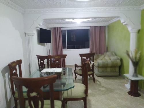 佛罗里达布兰卡Apartamento Cañaveral的客厅配有玻璃桌和椅子