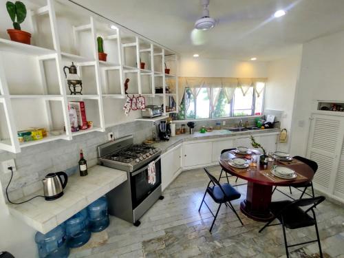 坎昆casa HIKURI的厨房配有桌子和炉灶。 顶部烤箱