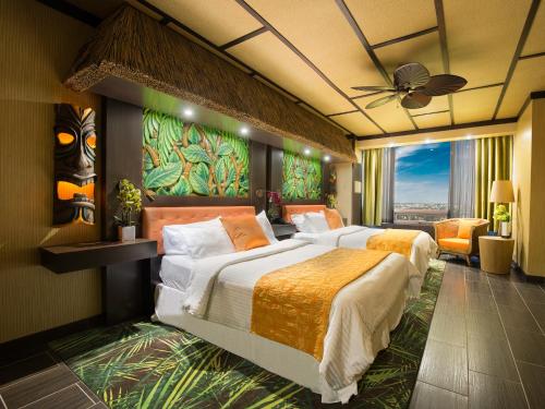 埃德蒙顿幻想世界酒店的一间卧室配有两张床和吊扇