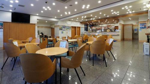 仙台Toyoko Inn Sendai Nishi-guchi Hirose-dori的自助餐厅内带桌椅的餐厅