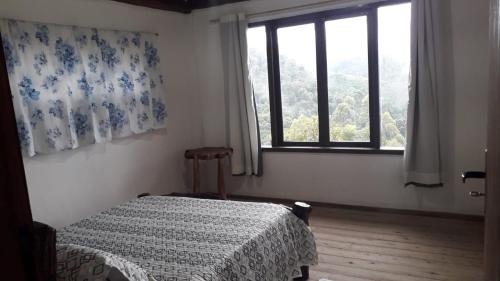 阿尤鲁奥卡Chalé Sabiá的一间卧室设有一张床和一个窗口