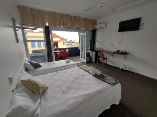 艾尔Ayr Hotel的一间卧室设有两张床和大窗户