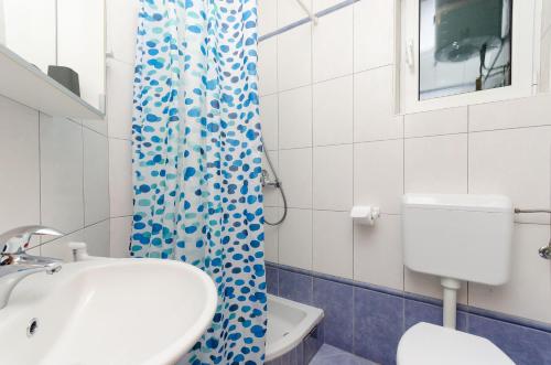 洛帕Apartments Ruzica M的浴室配有水槽、卫生间和浴帘