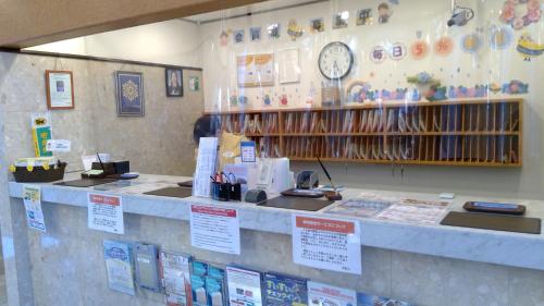 福岛Toyoko Inn Fukushima eki Nishi guchi的墙上挂着时钟的商店柜台