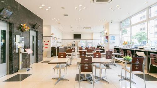 山形市Toyoko Inn Yamagata-eki Nishi-guchi的大楼内带桌椅的自助餐厅