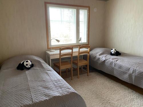 艾赫泰里Moksunsalo的一间卧室配有两张床、一张桌子和一把椅子