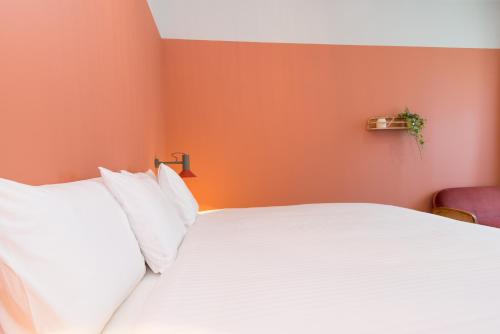 奥良Casa Rosa Villa with Pool in Olhao Centre的一间卧室配有白色的床和橙色的墙壁