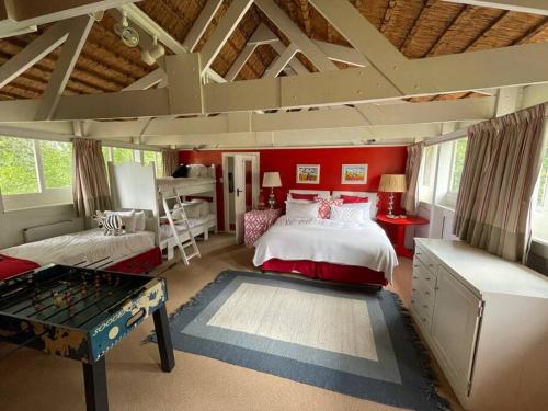 诺丁汉路Spring Close Boutique Cottage Nottingham Road的卧室设有红色的墙壁、一张床和一张桌子