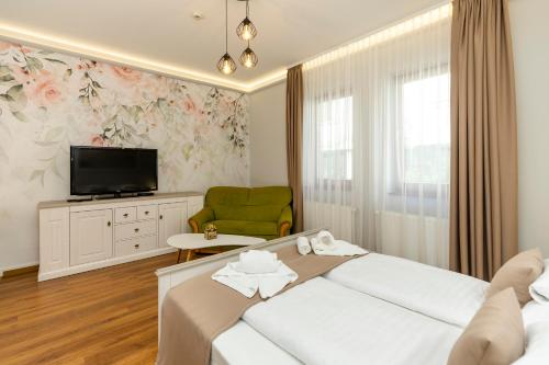 埃格尔Servita Udvarház Eger的一间酒店客房,配有一张床和一台电视