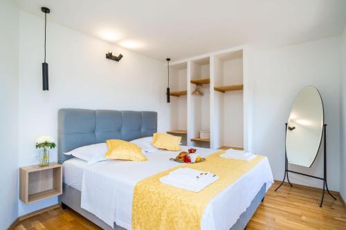 巴比诺波尔杰House Abatros的一间卧室配有一张带蓝色床头板和镜子的床