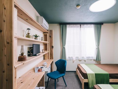荒尾Noasobi Lodge 203- Vacation STAY 23343v的客房设有一张床、一张桌子和一把椅子。