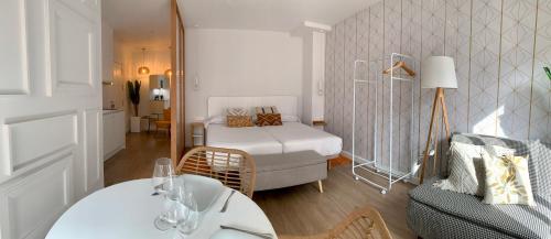 普拉森西亚Apartamentos Succo的配有床、桌子和沙发的房间