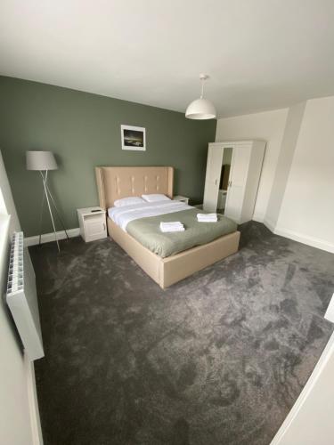 布里德灵顿Bridlington Shore Apartment的一间卧室设有一张床和绿色的墙壁