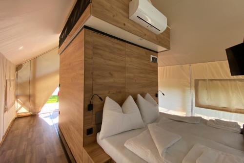 奥西亚歇尔湖畔施泰因多夫Comfort Safarizelt direkt am Ossiachersee的卧室配有一张白色大床和木墙