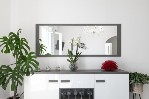 普莱伊亚诺Casa Clara的白色房间镜子,在柜台上放着鲜花