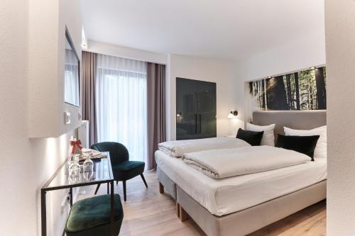 霍夫比伯洛萨马伊故居伯格酒店的白色卧室配有床、桌子和椅子