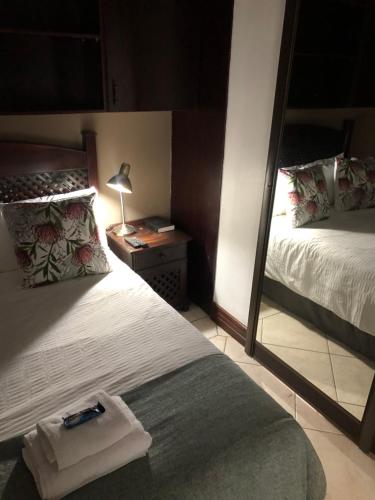 比勒陀利亚卡萨弗洛拉旅馆的一间带镜子、一张床和镜子的卧室