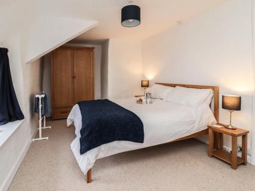 欧克汉普敦Lavender Cottage的卧室配有一张白色大床和两盏灯。