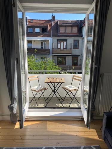 不莱梅Schönes 2-Zimmer-Apartment in Bremen, Findorff的通往带桌椅的阳台的开放式门