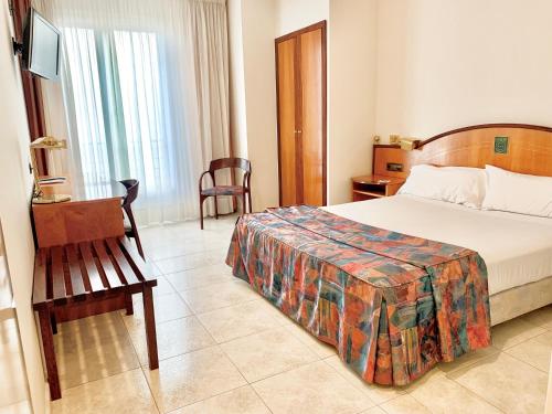 Santa Eugenia de Berga阿鲁米酒店的配有一张床和一把椅子的酒店客房