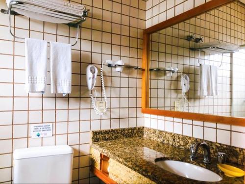 伊利亚贝拉Ilha Flat Hotel Suíte Bella - 4207 - Ilhabela的一间带水槽、镜子和卫生间的浴室