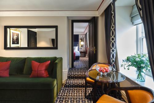 伦敦The Mayfair Townhouse - an Iconic Luxury Hotel的客厅配有绿色沙发和桌子