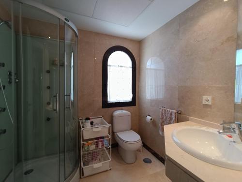 阿尔加德萨Amplio apartamento en Portofino Alcaidesa的浴室配有卫生间、淋浴和盥洗盆。
