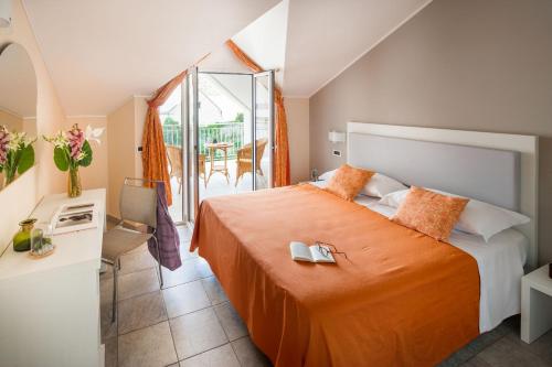迪亚诺马里纳迪亚诺史波堤公寓酒店的一间卧室配有一张带橙色床罩的床