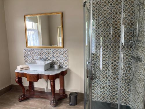 科芙Inver的浴室配有盥洗盆和带镜子的淋浴