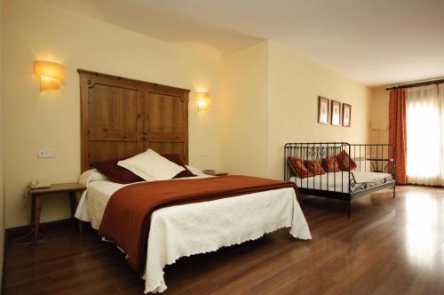 卡斯特洪德索斯比利牛斯山酒店的一间卧室配有一张大床和木制床头板