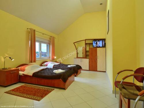 弗罗茨瓦夫帕拉迪索别墅旅馆的一间卧室配有一张床和一台电视