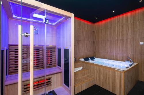 兰斯Art Déco Champagne & Spa的浴室配有紫色照明的浴缸