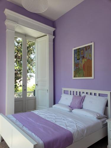 皮雅诺迪索伦托Caluga House的一间卧室设有紫色的墙壁和一张大床
