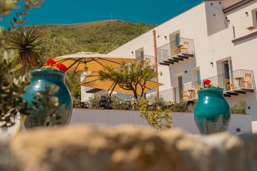 切法卢Villa Totò Resort的坐在大楼前的三个蓝色花瓶