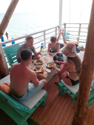 巴尔posada donde Uriel Playa tranquila的一群人坐在船上的桌子旁