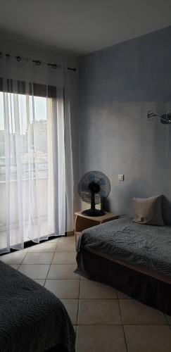 卡尔维Très bel appartement,proche plage et centre ville.的一间卧室设有两张床和大窗户