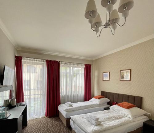 奥尔库什Apartamenty Centrum的酒店客房设有两张床和吊灯。
