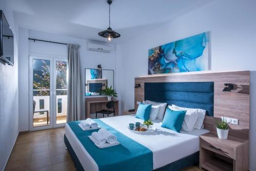 赫索尼索斯福拉瑞酒店的卧室配有蓝色和白色的床,提供毛巾