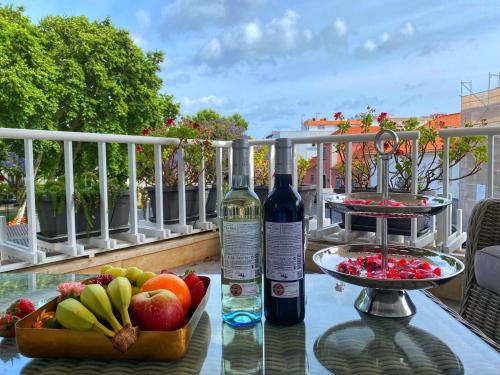 卡斯卡伊斯Cascais Sun Apartment的一瓶葡萄酒和一碗水果放在桌子上