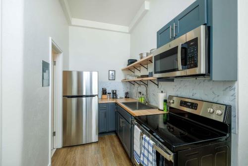 利文斯顿MT Block Unit 17 Madison的厨房配有蓝色橱柜和不锈钢冰箱
