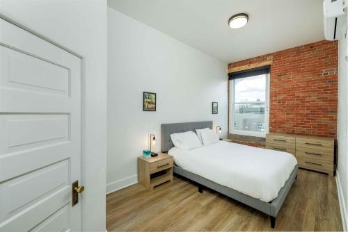 利文斯顿MT Block Unit 17 Madison的一间卧室设有一张床和砖墙