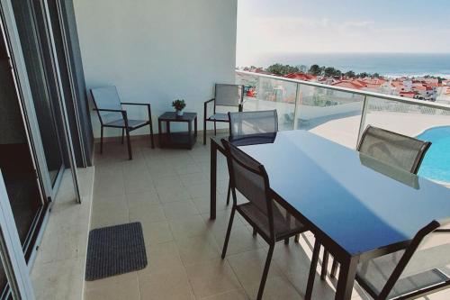 纳扎雷Brisa do Mar Ap.的一个带桌椅的阳台和一个游泳池